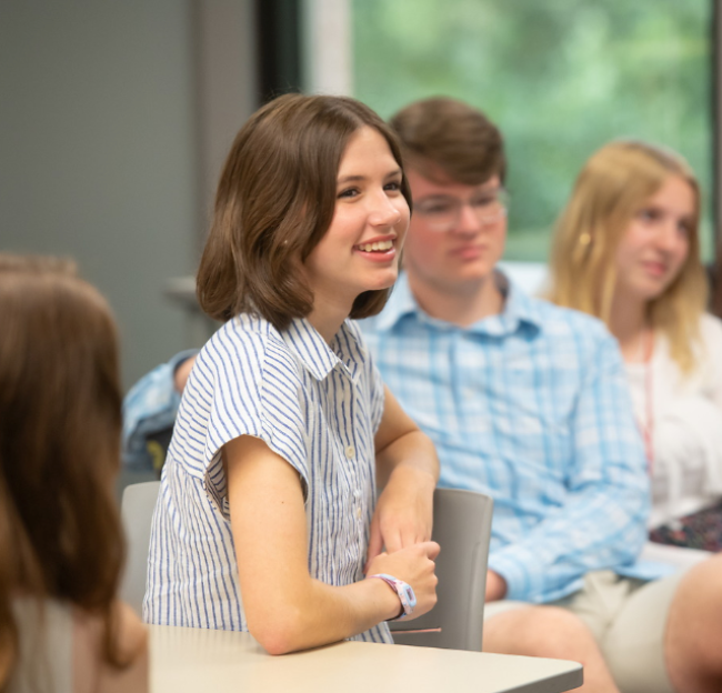 Student speaking in a class among peers.