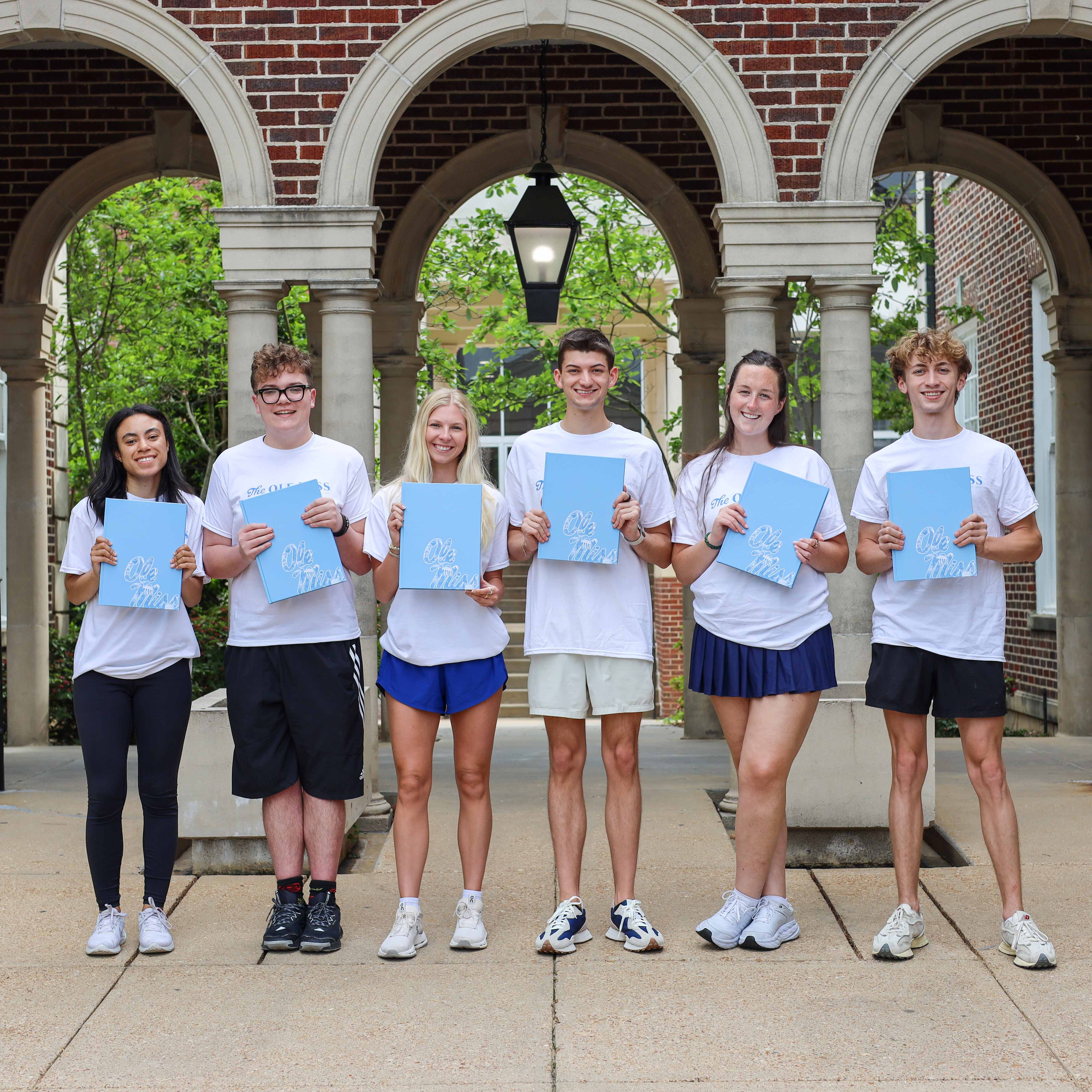 Students pass out yearbooks to others.