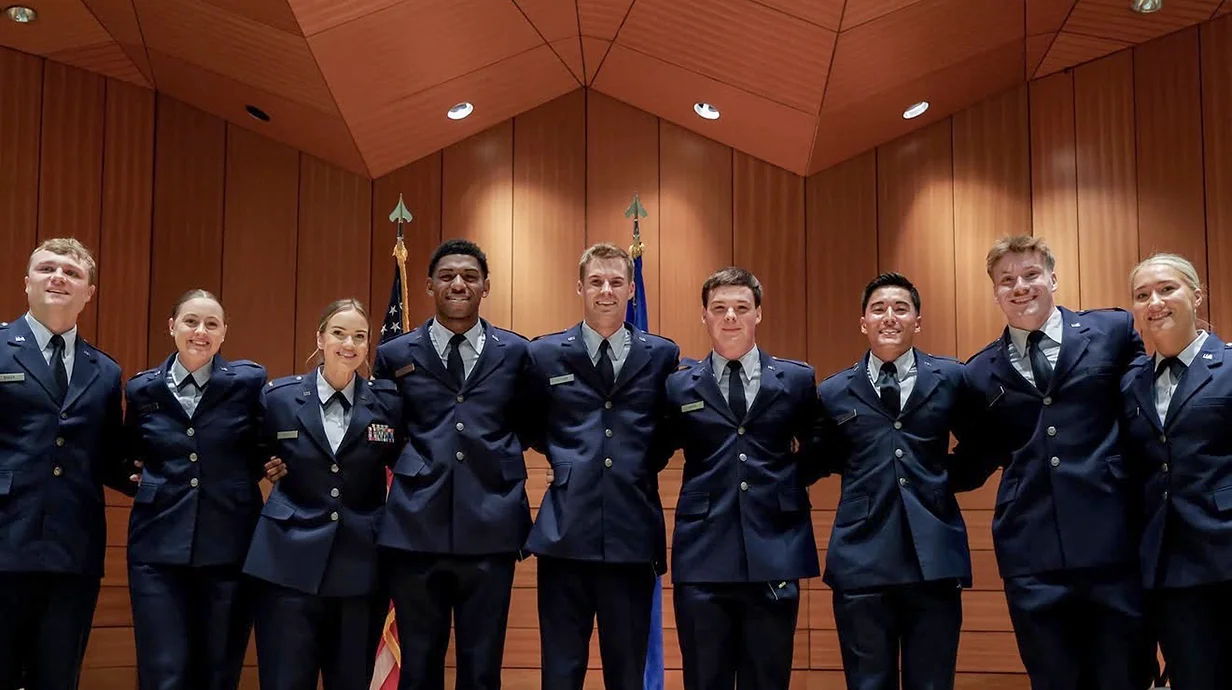 image of a group of students in uniform with wood paneling in bakground