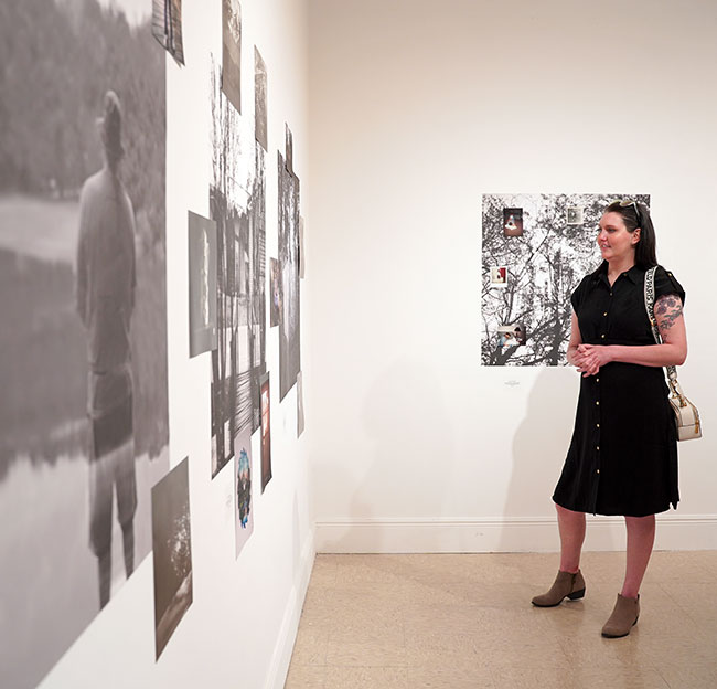 woman looking at photographs on wall in exhibition