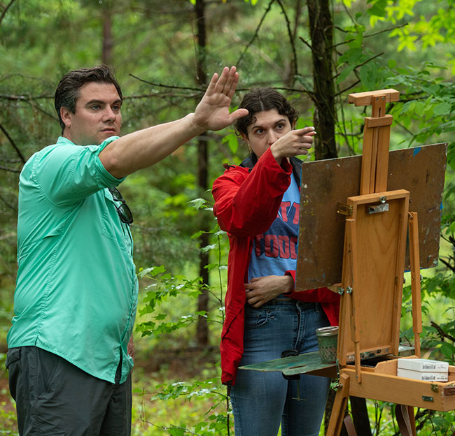 teacher with student painting outdoors