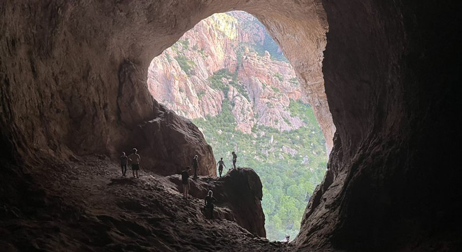 Students explore a cave in the Arizona mountains