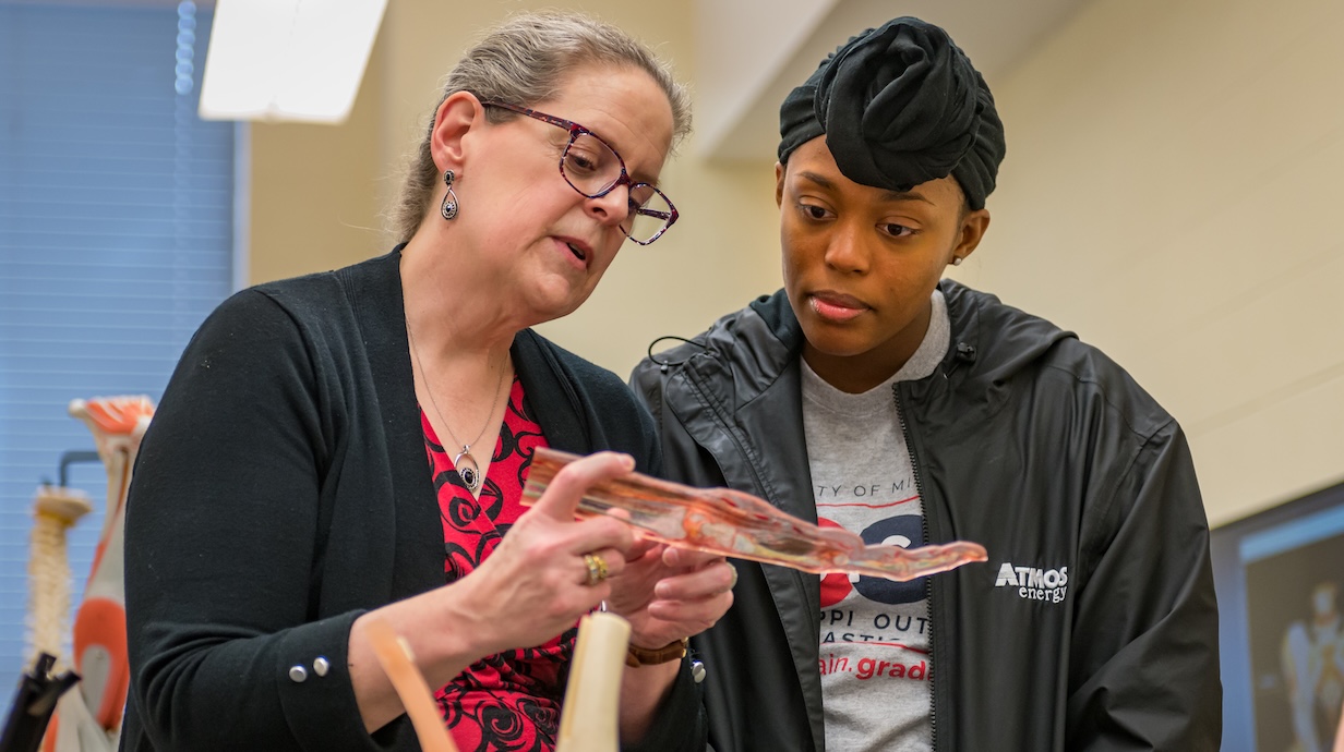 professor explaining the parts of a hand to a student