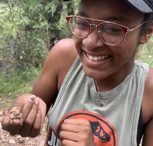 Image of a smiling girl holding a frog.