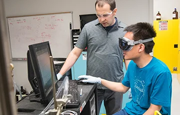 Two people in chemistry lab looking at a computer