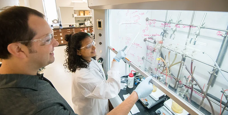 two people in a lab looking at lab equipment