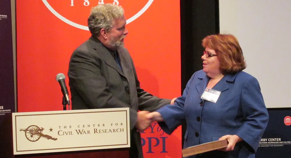 man and woman shaking hands at podium