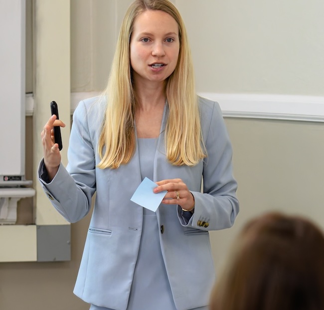 Professor Clara Piano stands to teach a class