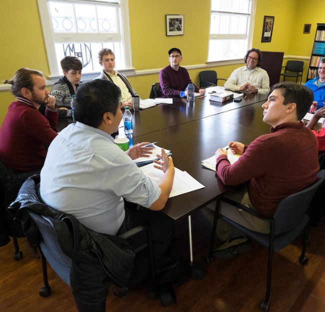 students sit around a table during class