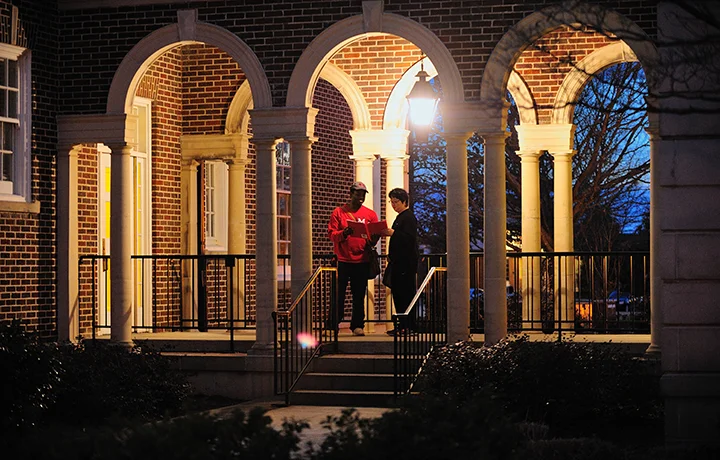 two people standing in a portico at night
