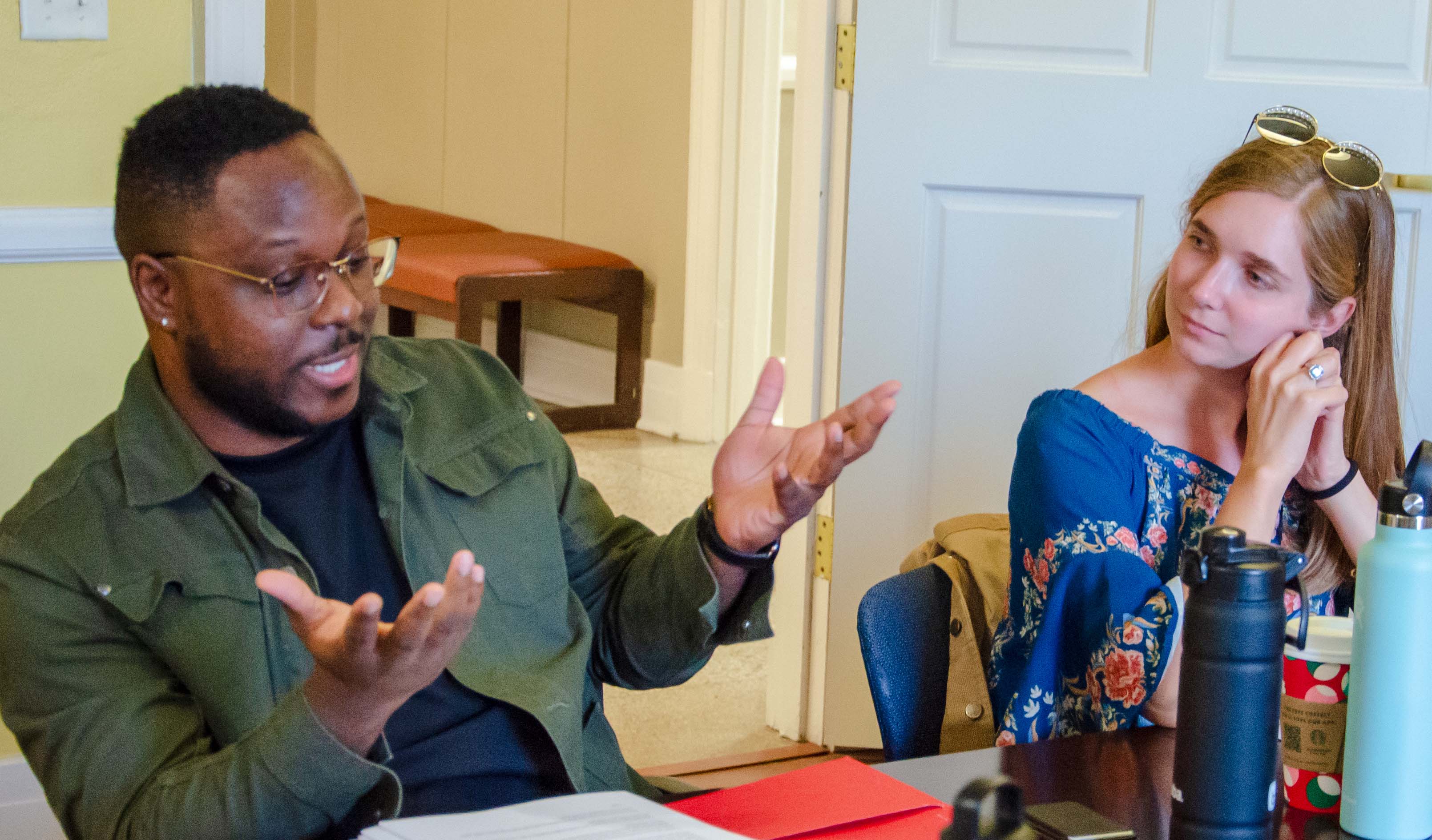 graduate students sit around a table in a classroom