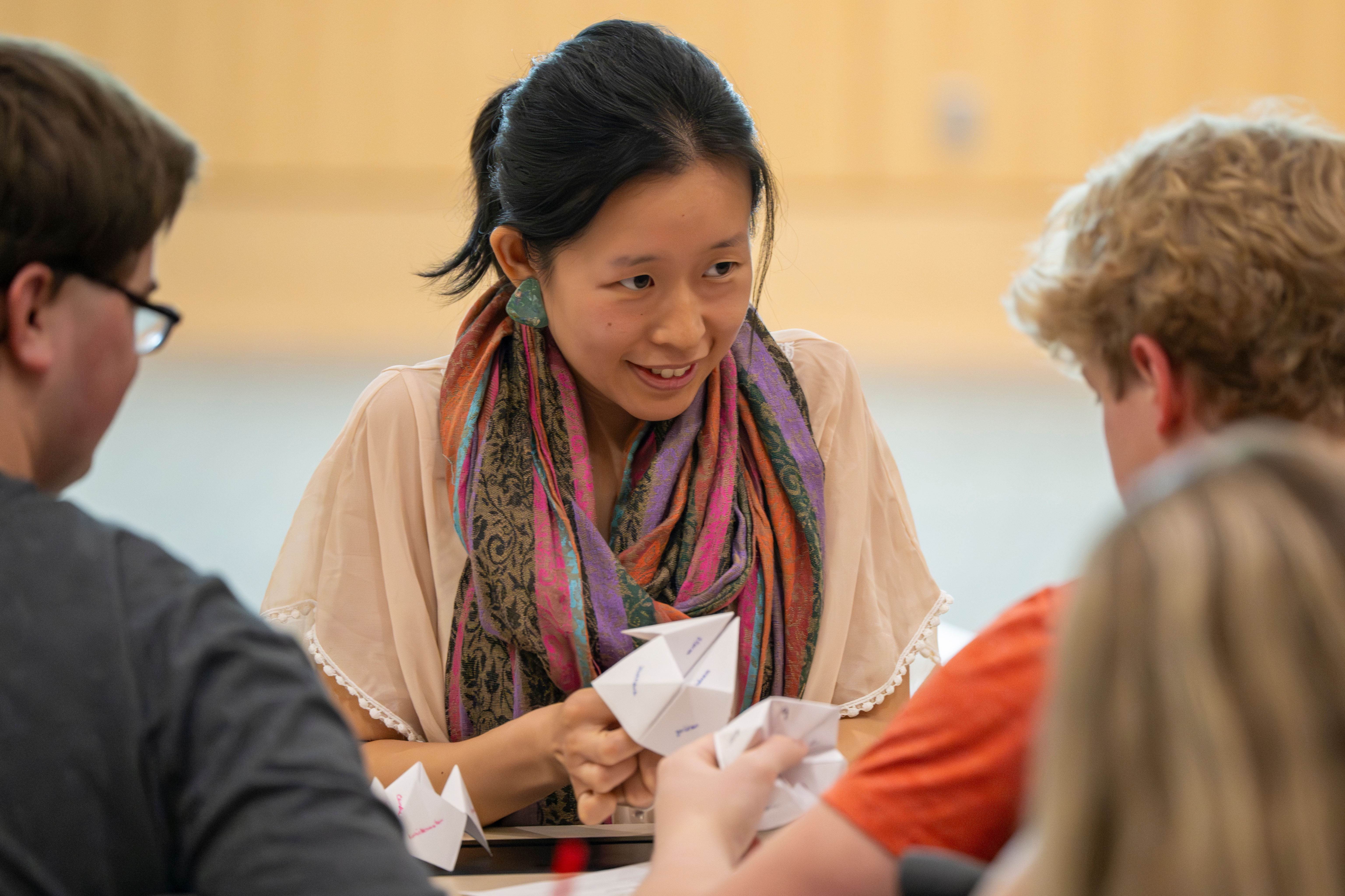 teaching assistant helps student with hands-on activity during classtime