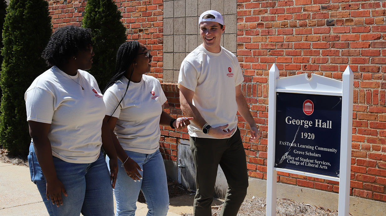 students walking by George hall sign