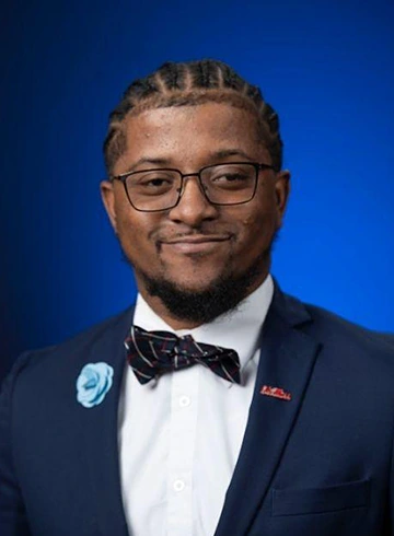 Justin Stevenson formal portrait with blue background