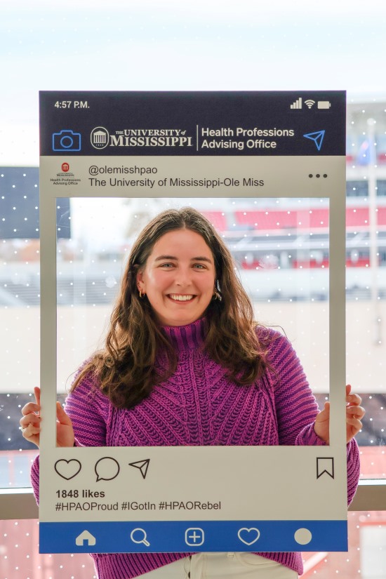 woman posing for a photo with a social media prop