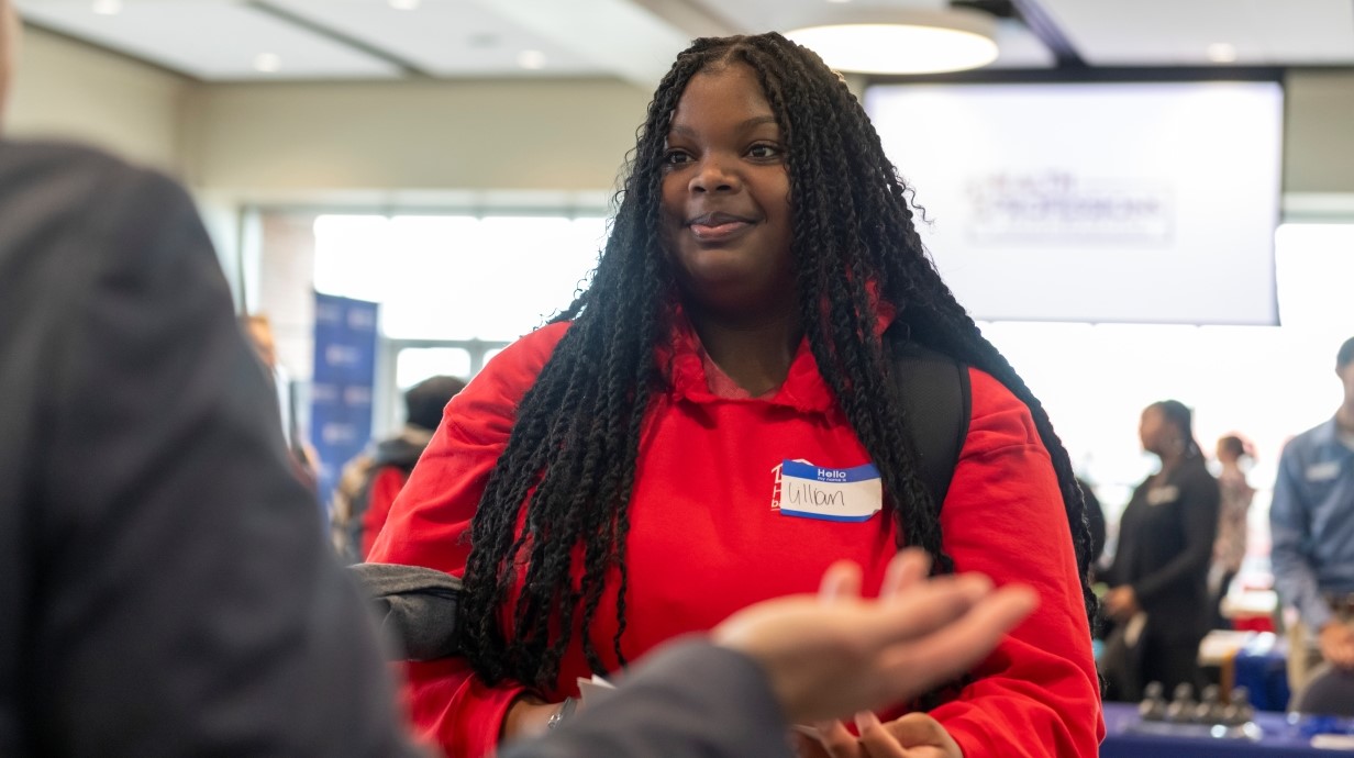 image of a student standing at a table getting information