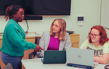 three students studying together in a room