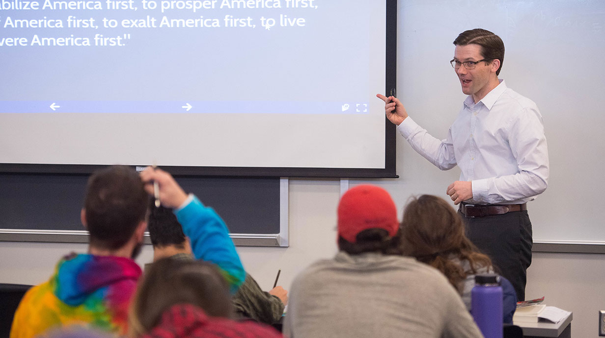 Professor standing in front of classes and giving a lecture