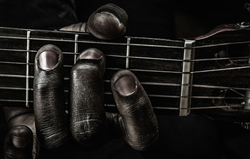 close up of a hand holding a guitar