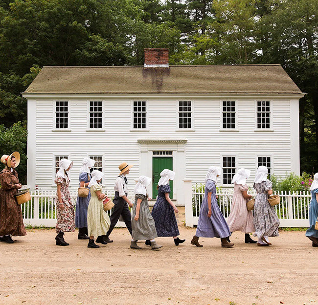 people walking by in front of a white building