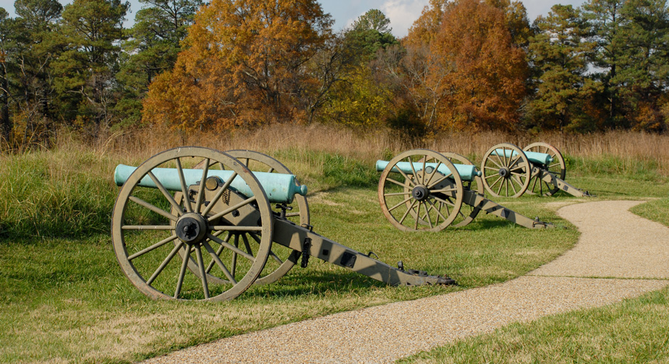 three cannons on a grassy field