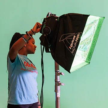 theatre student adjusts lighting on set