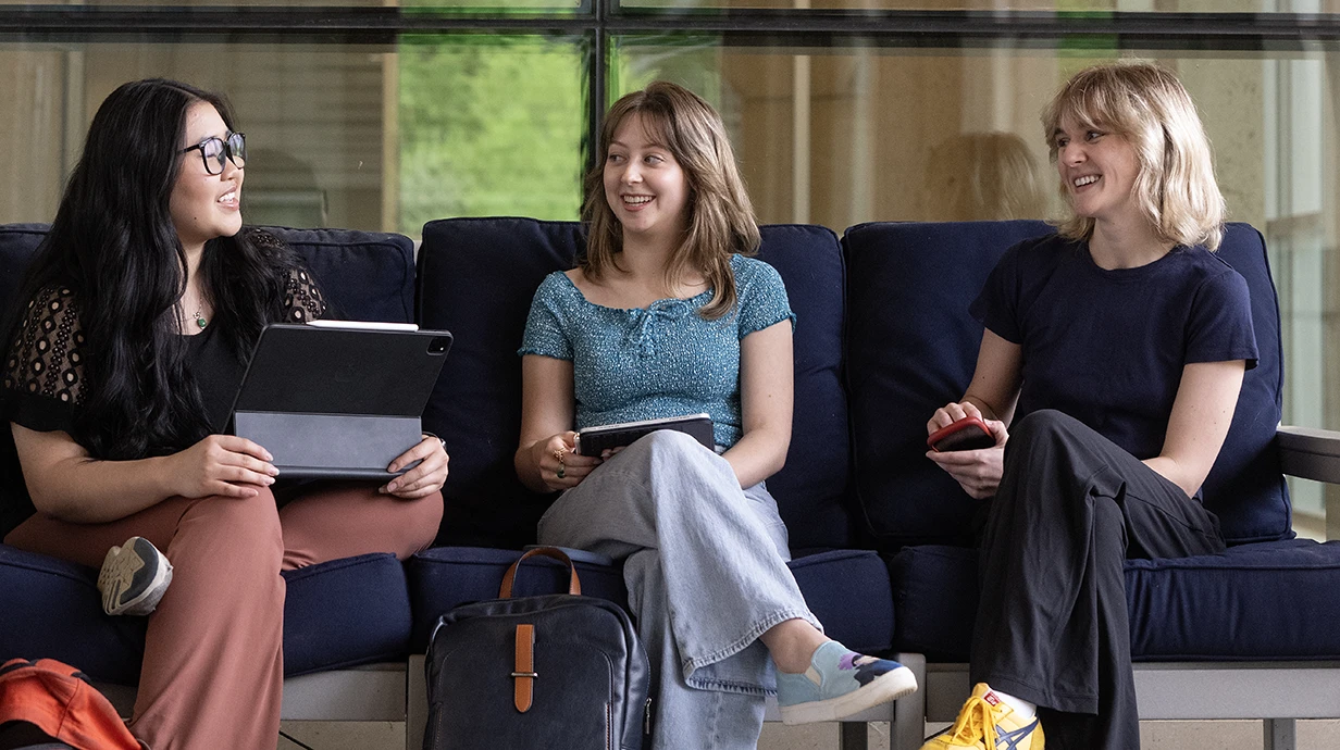 students sitting together talking while seated on a couch in the Union bookstore