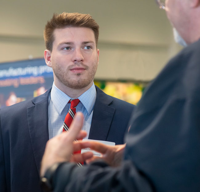 male student listening to someone talk to him