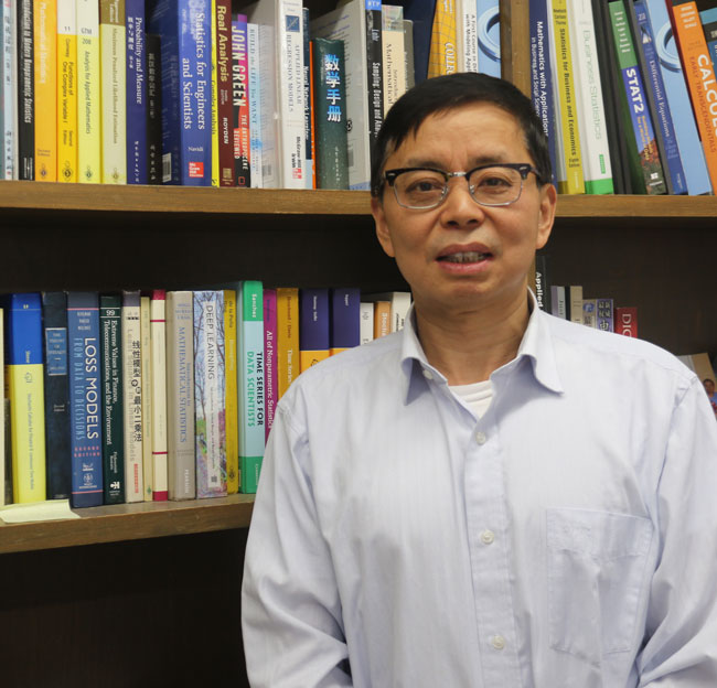 Headshot of Hailin Sang with books in the background
