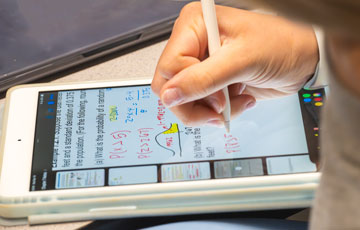 hand writing math notes on a tablet