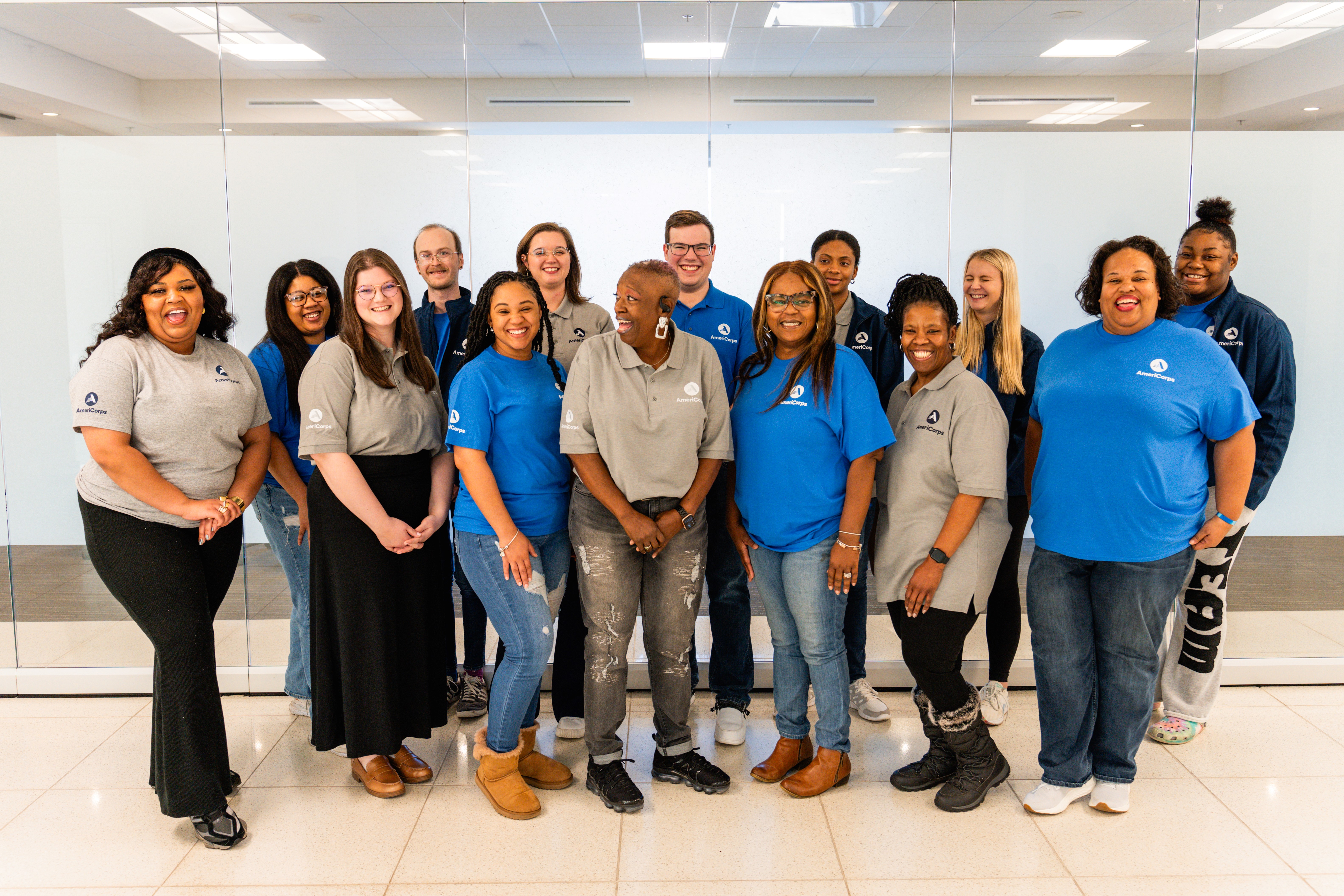 Members of the North Mississippi VISTA Project pose in front of a clear glass wall.