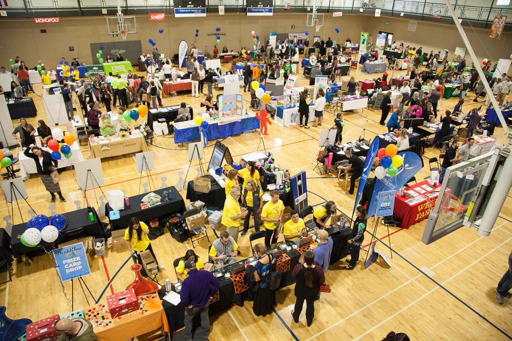 A series of tables on a basketball court hosting a health fair.