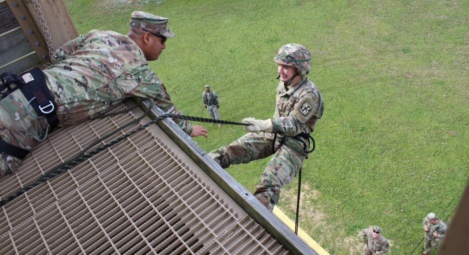 student is rappelling down a tower while holding a rope