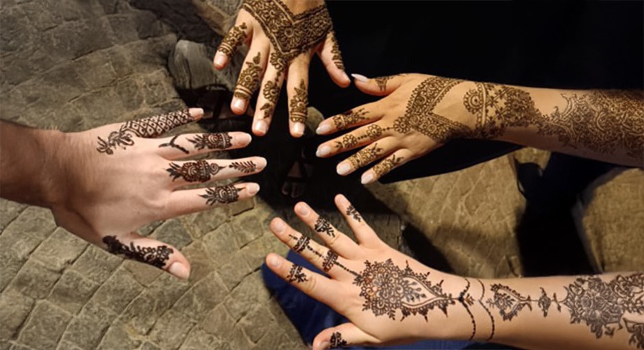 a photo of hands and arms decorated with henna tattoos