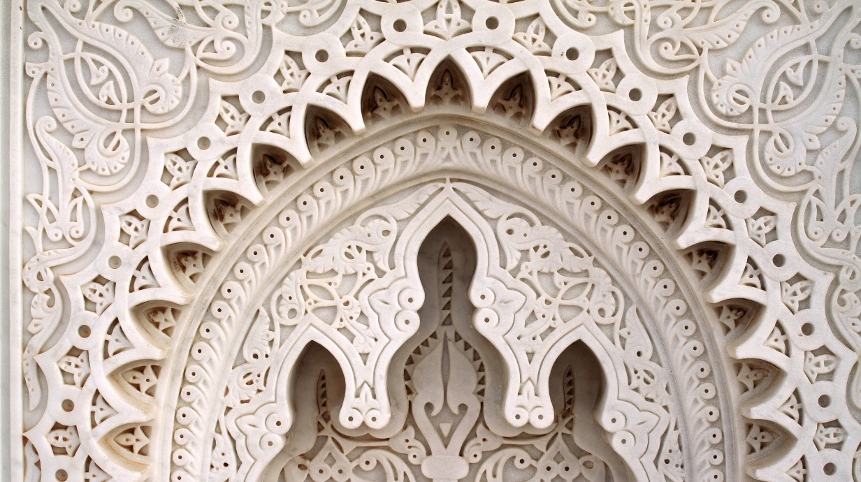 elaborately carved white architectural detail around a window to represent the Arabic culture