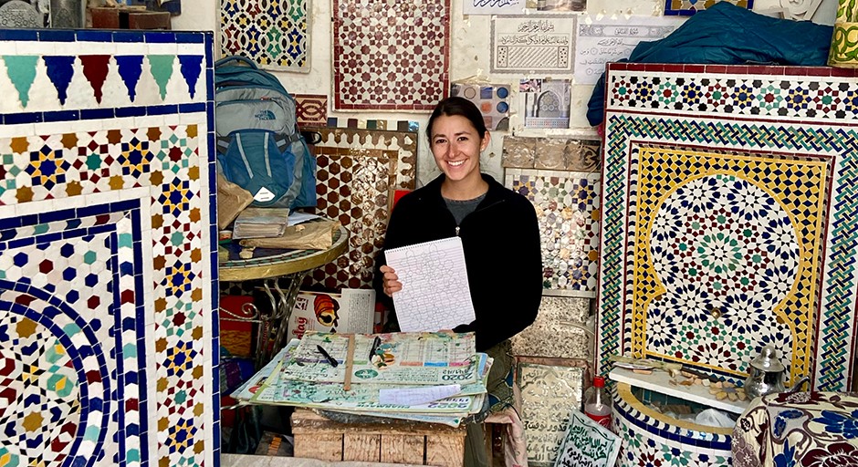 student seated in a colorful stall in a market of Moroccan artisan gifts