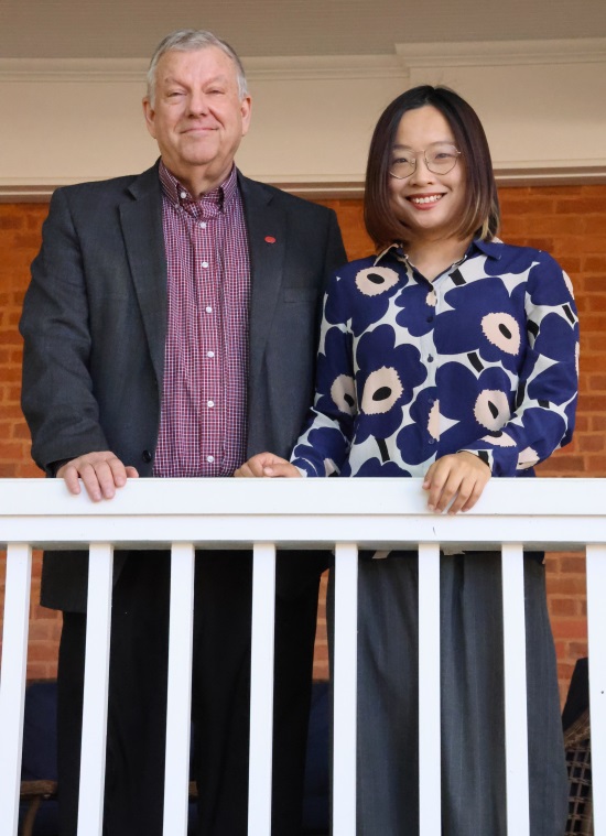 image of Don Dyer and Zhini Zeng standing together behind a white railing