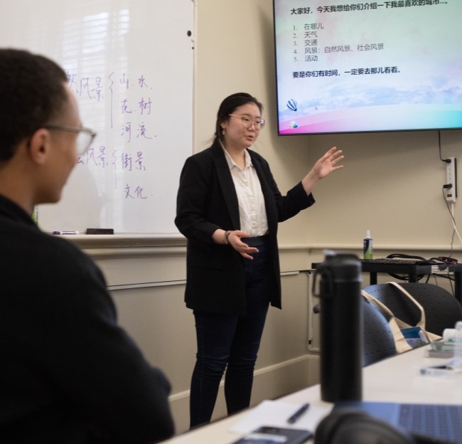 image of a student standing in front of a whiteboard while giving a presentation to a class