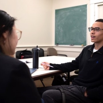 image of two students seated together talking