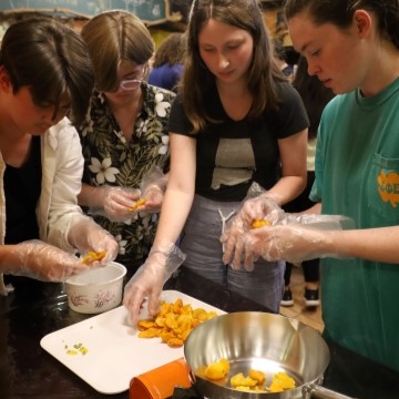 image of students standing around a table and preparing food