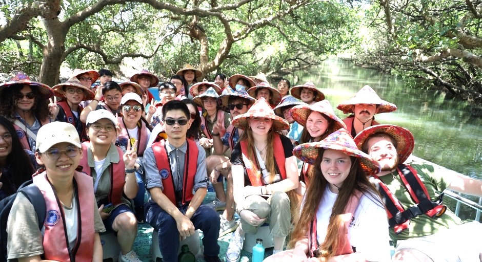 students in a boat with straw hats