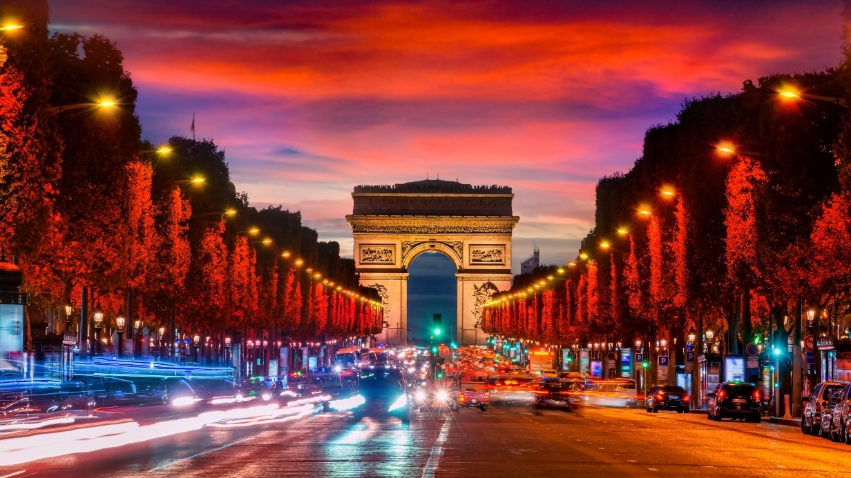 Illuminated Champs Elysee and view of Arc de Triomphe in parisian evening, France