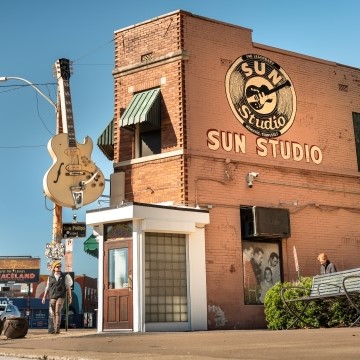 image of the outside of the Sun Studio building with a large guitar and the logo on the side of the building