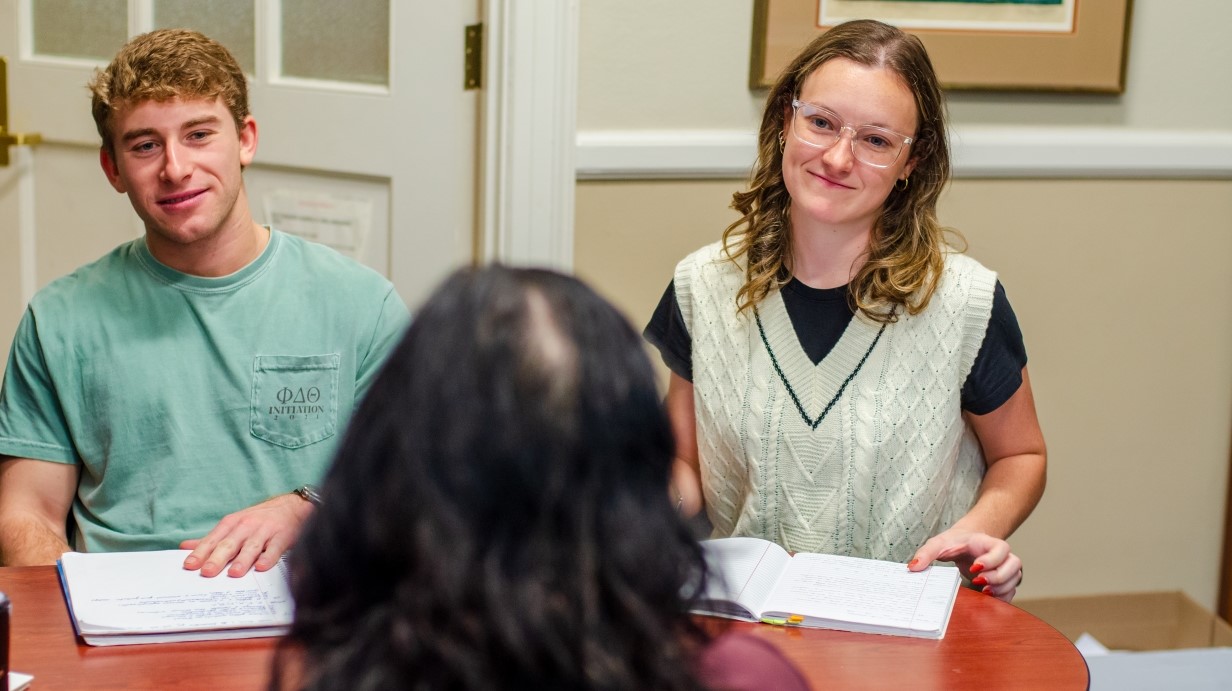 professor sitting with two students seated in an office