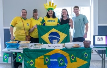 image of a group with Brazilian shirts standing behind a table with items related to Brazil