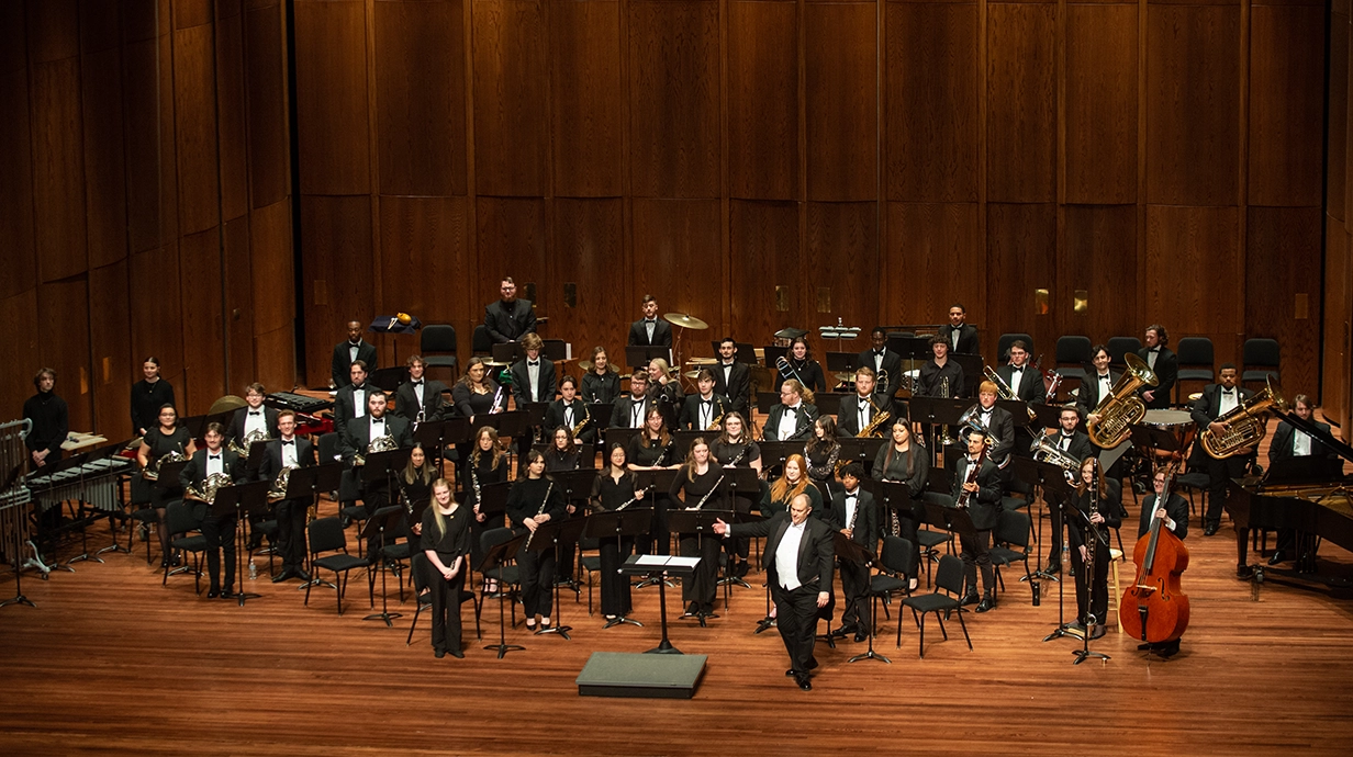 wind ensemble stands on stage of the Ford Center following a performance