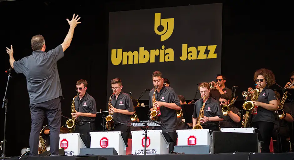 A group of saxophone players at Umbria Jazz festival playing in front of the director