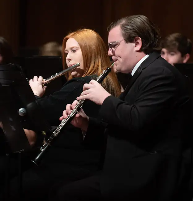 Band members play wind instruments in harmony 