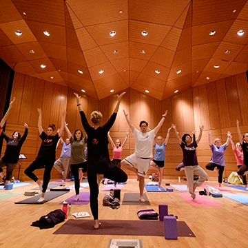 A class of students does a yoga pose