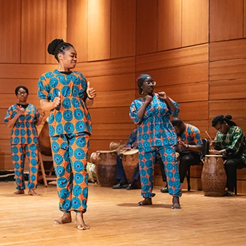 Members of the African drum and dance ensemble dance and play the drums in their African dress